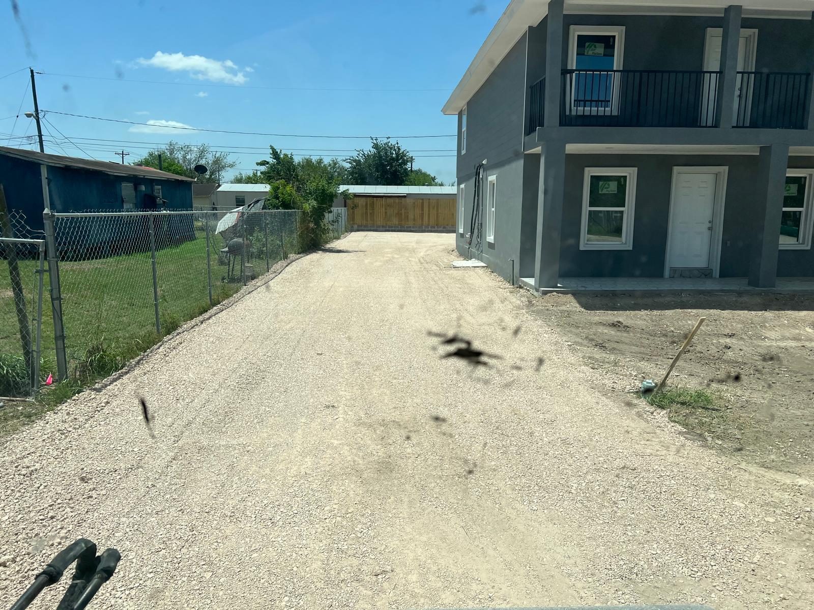 Caliche driveway beside a two-story home