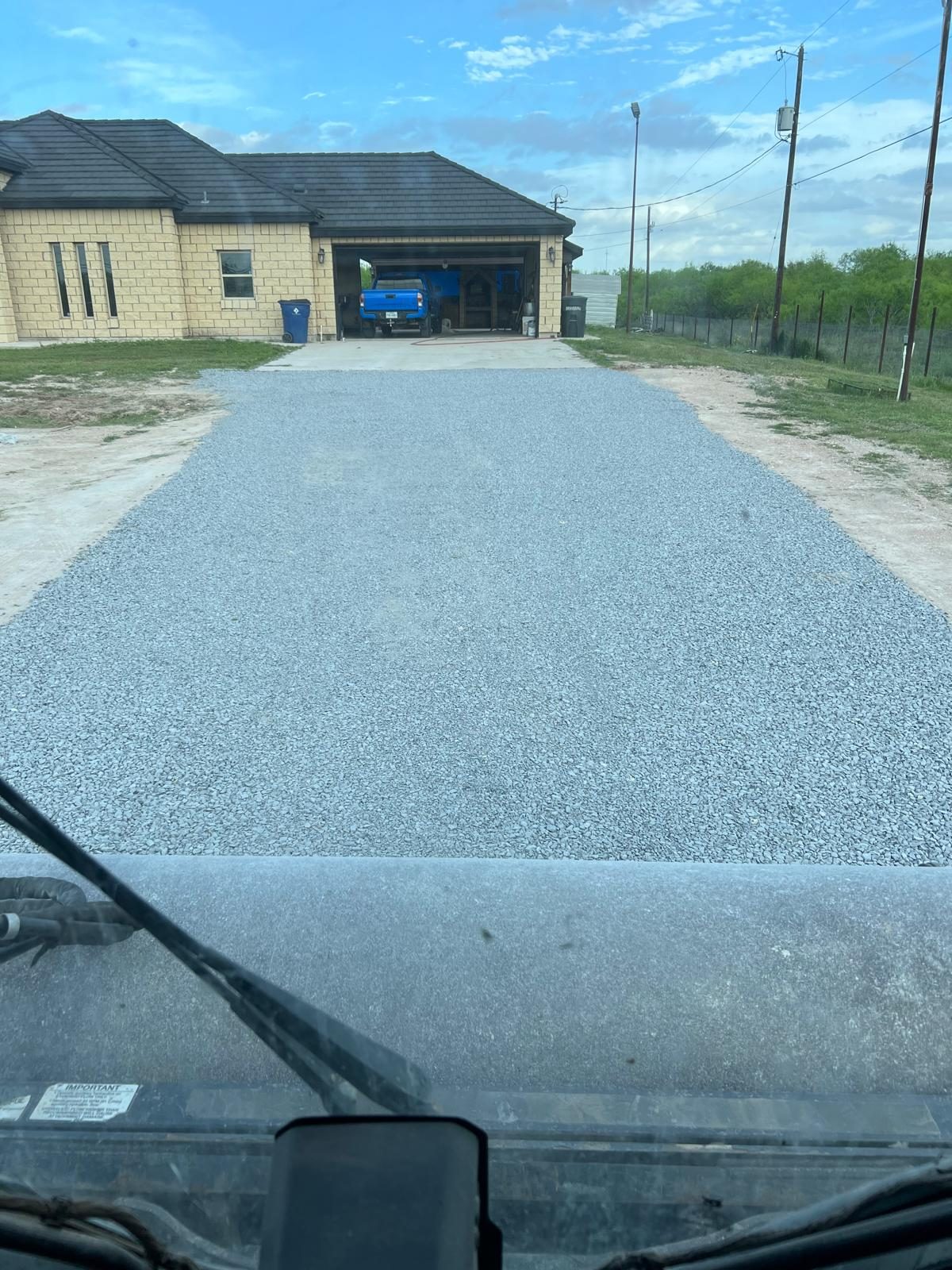 Fresh gravel driveway leading to a home