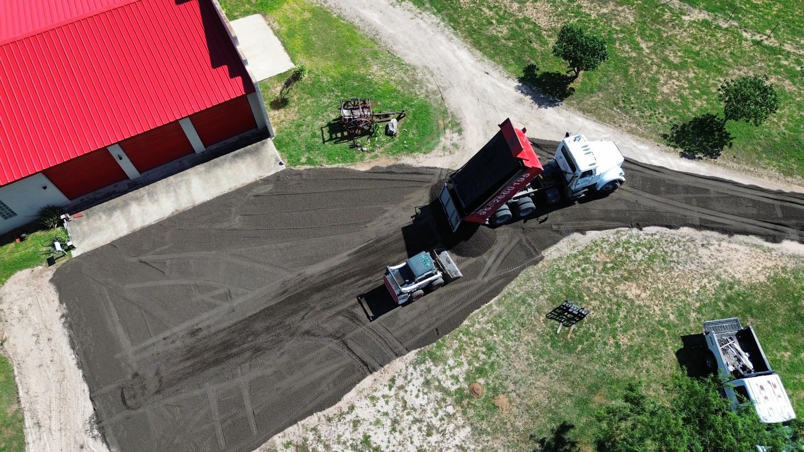 Aerial view of dump truck spreading material on a driveway