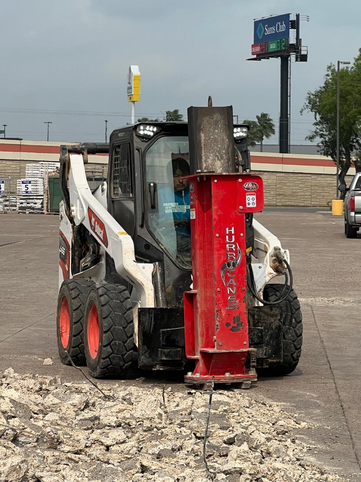 Skid steer with hydraulic breaker on concrete